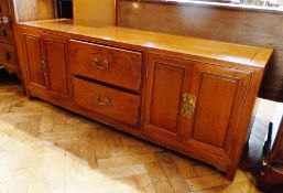 Modern oriental hardwood sideboard having two central drawers flanked by pair cupboards and having