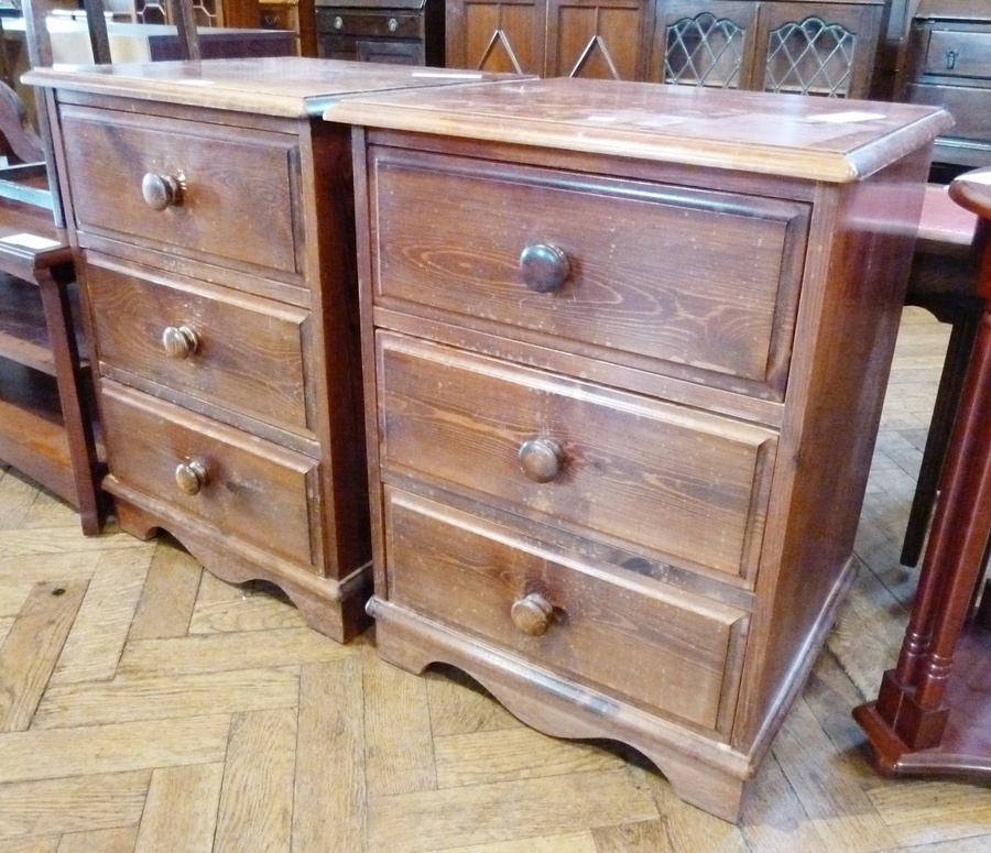 Pair stained pine bedside chests, each of three drawers with turned knob handles