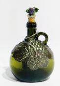 An art nouveau green glass wine bottle with foliate pewter and figure shoulders with grape finial to