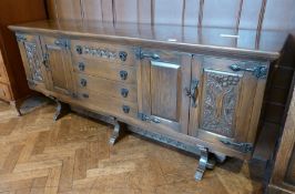 Reproduction oak sideboard with an arrangement of sledge central drawers flanked by two cupboards