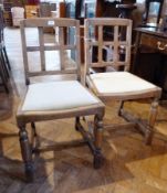 Three early 20th century oak dining chairs, each with square back, on cylindrical front supports