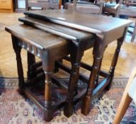 Nest of three reproduction oak coffee tables, each rectangular on turned supports, block feet and