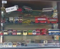 Collection of Corgi and EFE model double decker buses and coaches in a display case together with