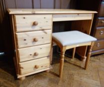 Pine kneehole dressing table having four long drawers with bun handles and padded topped stool,