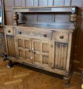 Mid 20th century reproduction oak sideboard having raised shelf on turned cup and cover supports the