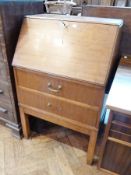 A reproduction mahogany bureau, the fall front enclosing a fitted interior with two drawers below on