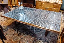 A large modern rectangular coffee table, with blue tiled top, wooden frame on wooden straight