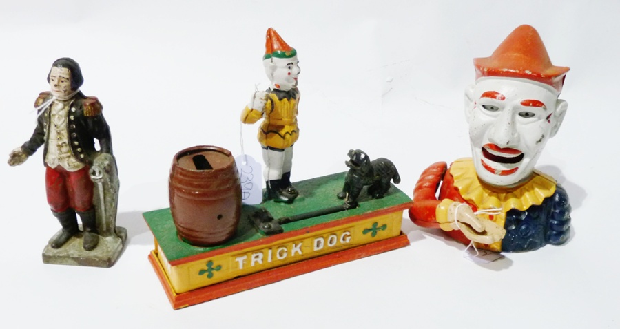 Painted metal clown moneybox, another in the form of Officer with sword and another trick dog in the