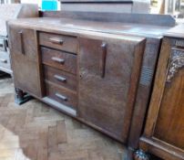 Mid twentieth century oak sideboard, with four short central drawers flanked by cupboards, on turned