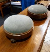 A pair of Victorian circular upholstered top footstools, walnut veneered with reeded brown glass