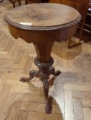 A Victorian walnut circular top sewing table, the hinged top opening to reveal fitted interior on