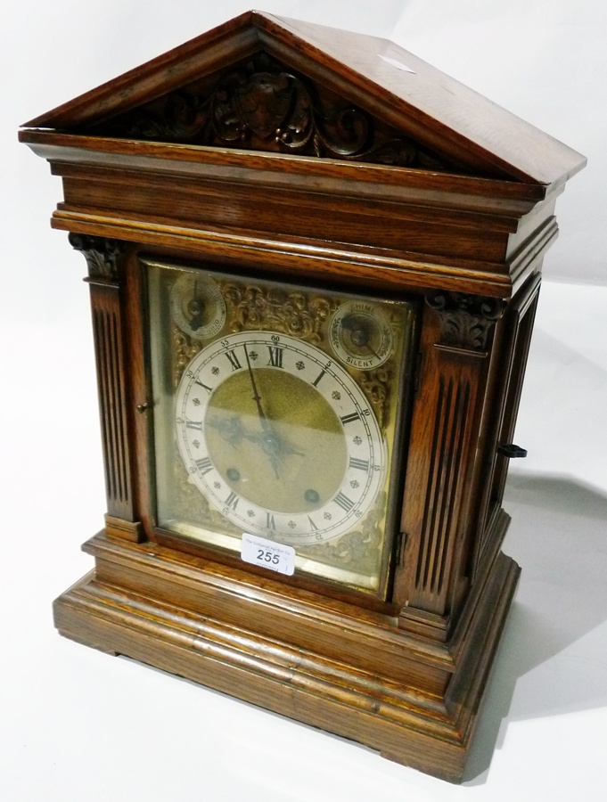 Victorian oak bracket clock with triangular pediment, shield and scroll carved, the brass dial