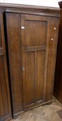 Early 20th century oak wardrobe, panelled door enclosing hanging space, on bracket feet, 88cm wide