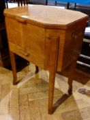 Arts and Crafts style oak sewing table, the hinged top opening to reveal a fitted interior, with