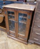 Reproduction oak glazed bookcase, with leaded light panel doors enclosing shelves, on bracket