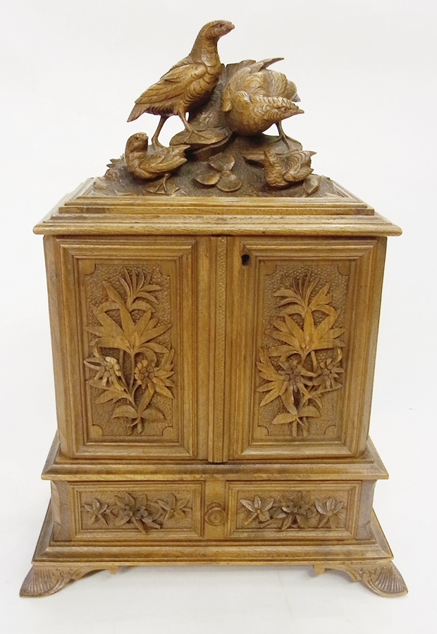 Black Forest carved walnut table cabinet, with partridge surmount, pair foliate carved panel doors