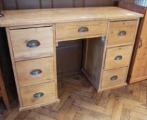 Modern pine kneehole desk with an arrangement of seven drawers around the kneehole, 119cm wide