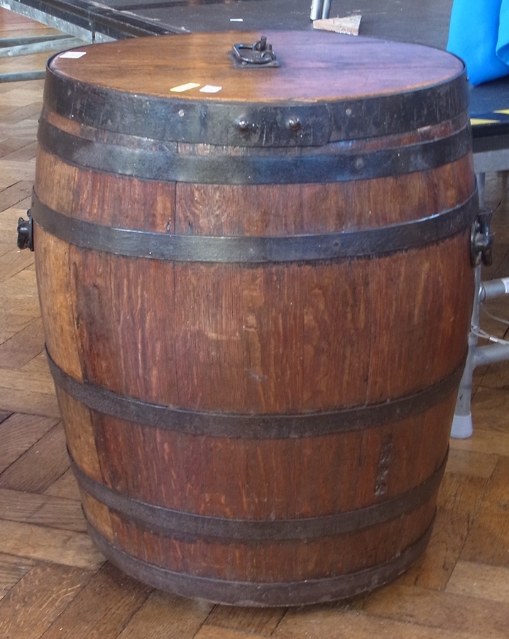 An antique oak barrel, with metal handled top with metal mounts, lift up lid, and handles to side,