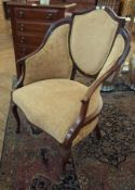 A mahogany shield back armchair, with satinwood banding, cream upholstery, on cabriole supports
