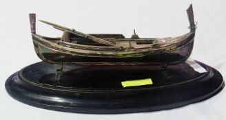 EPNS rowing boat of gondola form and the pair oars, 22cm wide, on ebonised, oval wooden stand