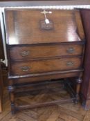 Early 20th century oak bureau with hinged lid below, enclosing pigeonholes above two long drawers on