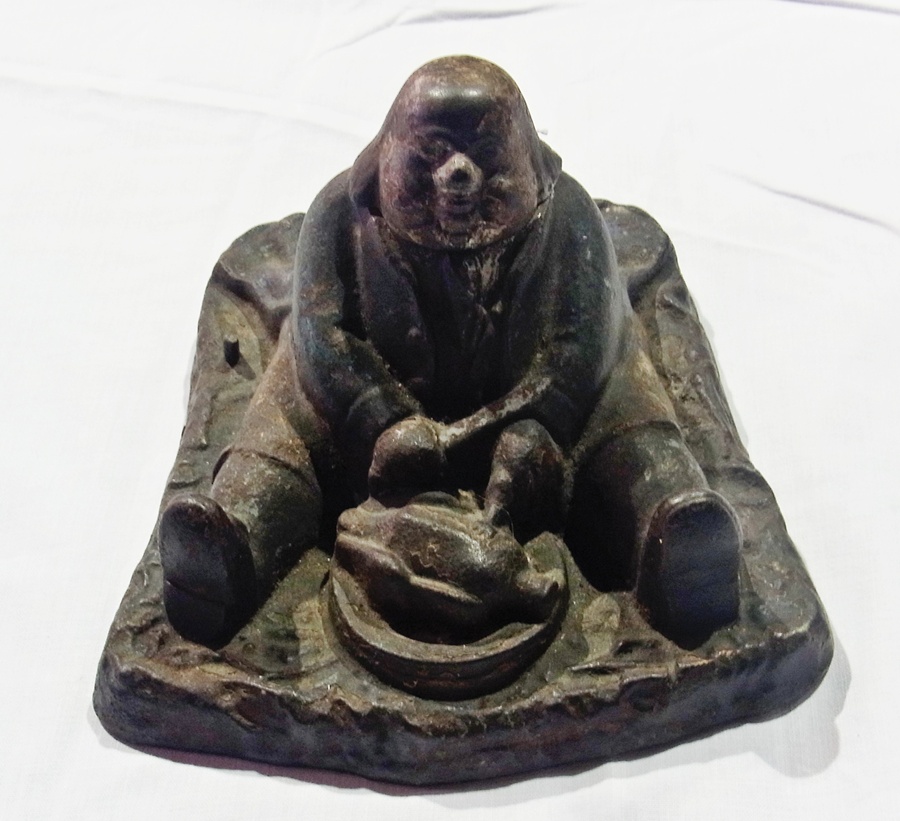 Victorian cast iron inkwell in the form of a man seated and eating roast chicken, 17cm wide
