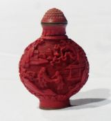 Oriental carved red lacquer snuff bottle, domed flowerhead stopper, embossed pagodas and figures