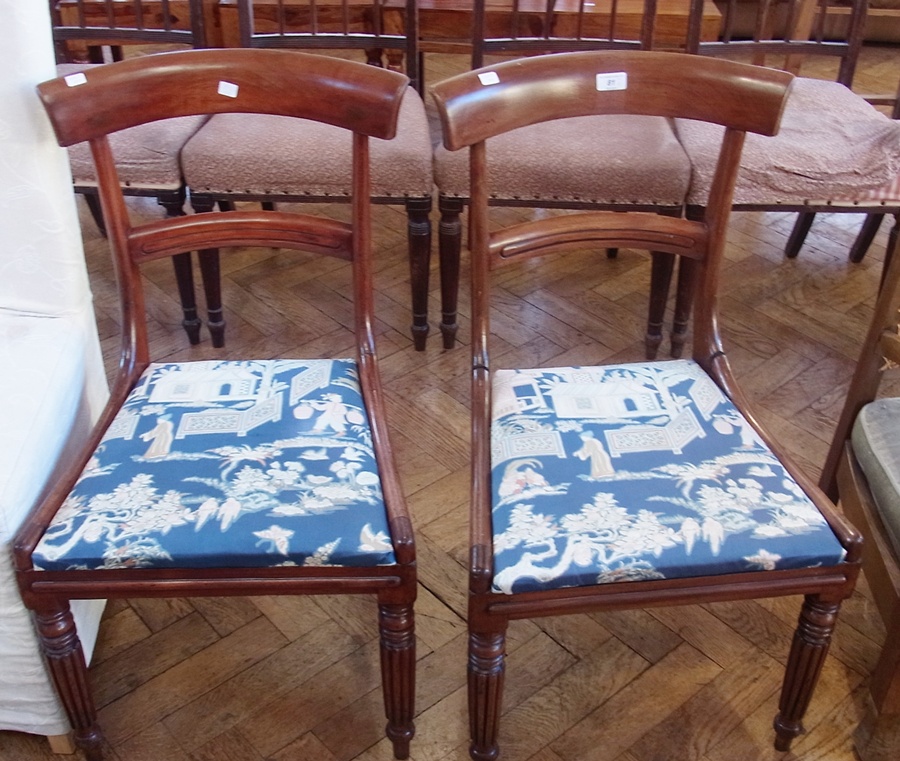 Two William IV mahogany dining chairs, each with curved shoulderboard, Trafalgar seat, on reeded
