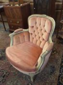 A painted green and gilt tub armchair, with pink studded upholstery, and cabriole legs with