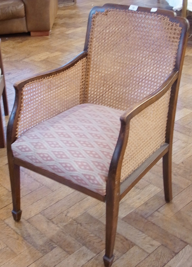 Early 20th century caned armchair with shaped square back, on square tapering supports, spade feet