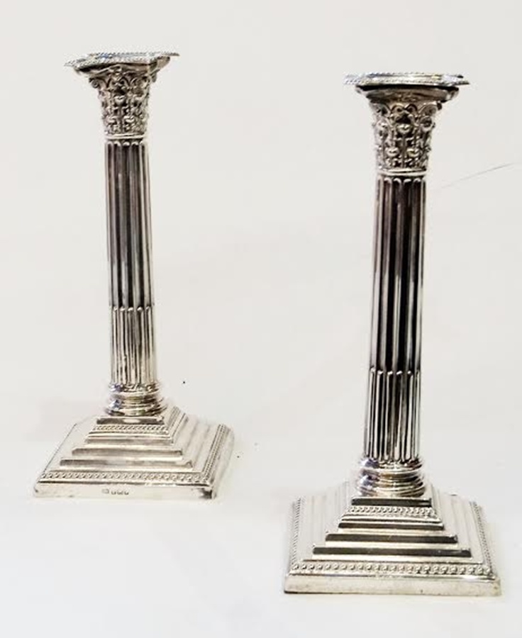 Pair Edwardian silver Corinthian column candlesticks, with removable drip trays, each on square