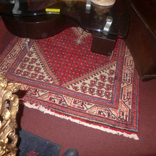 A Persian hand knotted Hamadan rug the rouge field with blue repeating motifs in a beige border