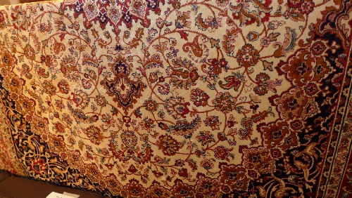 A Persian Keshan style carpet the beige field with central pendant medallion with extensive floral