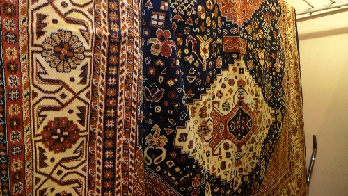 A Caucasion style carpet with blue and gold field and repeating geometric motifs