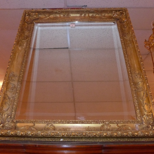 A C19th carved giltwood and gesso wall mirror with rectangular bevelled plate