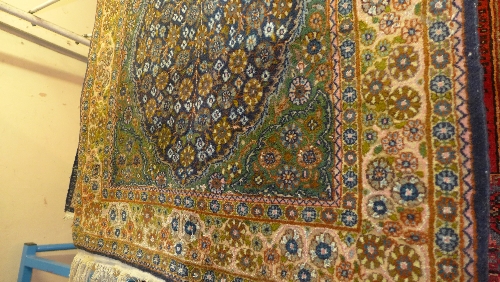 A Persian part silk Isfahan rug with green field and central pendant medallion