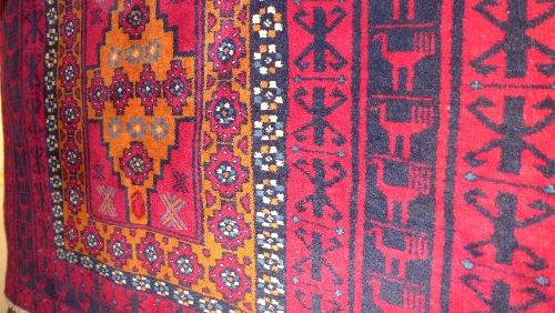 A fine North East Persian Meshad Belouch rug triple pole medallion on a rouge field within floral