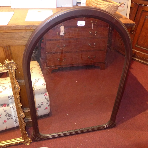 A hardwood framed wall mirror with arched plate