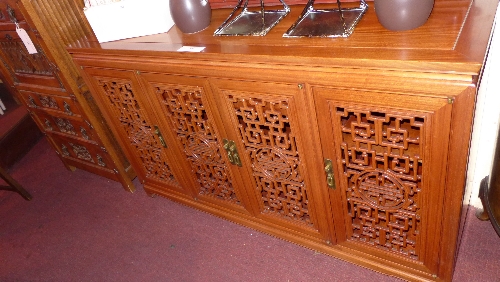 A Chinese rosewood sideboard fitted four carved and pierced panel doors