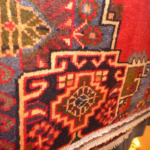 A Persian hand knotted Baktiar rug the red field with repeating floral patterns in a multicoloured