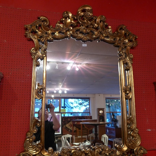 A French style wall mirror in shaped leafy gilt frame
