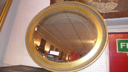 A C19th giltwood wall mirror with oval bevelled plate