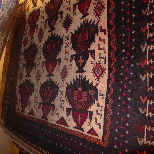 An extremely fine North East Persian Zabul Belouch rug repeating petal motifs on an ivory field