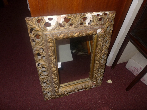 An early C20th wall mirror in carved and pierced giltwood frame (A/F)