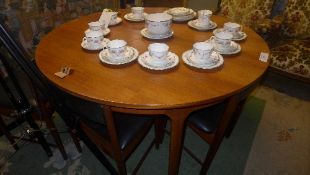 A teak Danish style extending dining table with six matching chairs