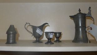 A quantity of pewter including a short flagon with flared base and decorative lid