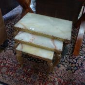 A gilt metal and onyx nest of three tables