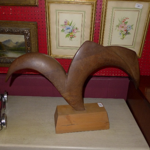 A contemporary wooden sculpture monogrammed B.J. on stand