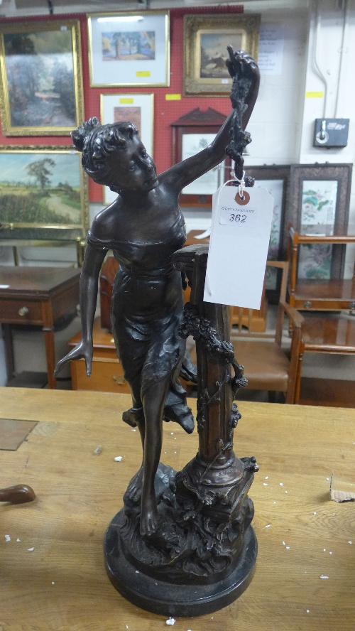 A bronze classical figure of a lady with grapevine column