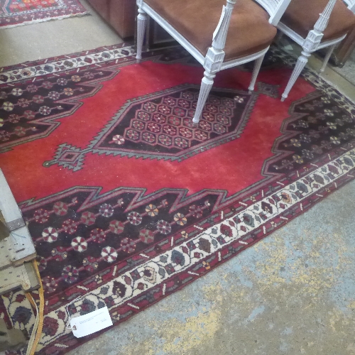 A Hamadan style carpet with central medallion on red field within beige border